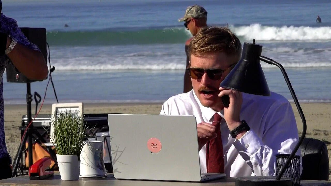 Man embraces remote work by setting up offices at the beach, baseball game