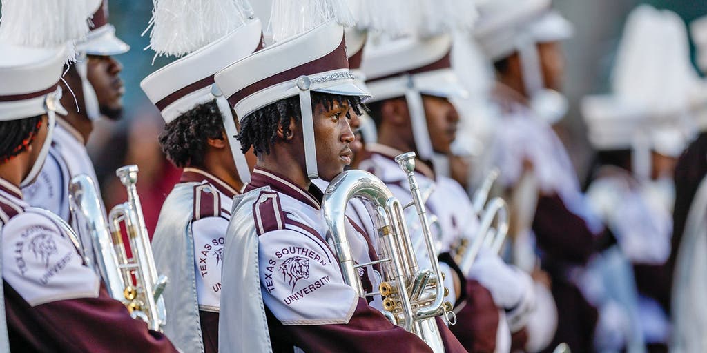 Marching band tuba player unleashes punches on man at college football game without missing a beat
